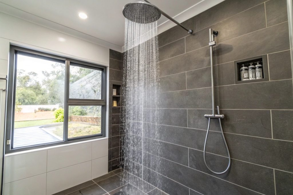 Walk-in shower with water running in Hobart bathroom showing waterproofed surfaces