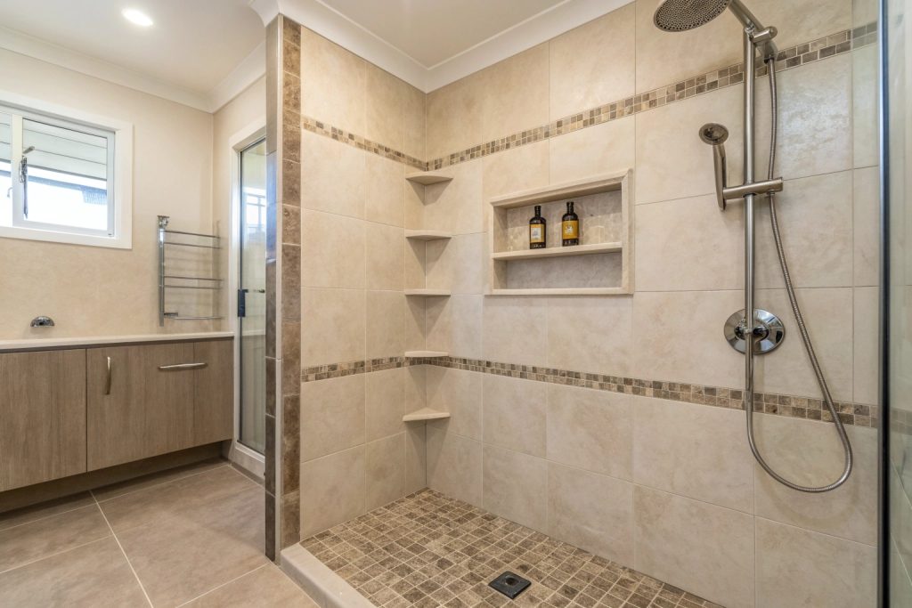 Corner walk-in shower with niche shelving and textured non-slip floor tiles